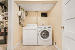 Dedicated laundry area with tile flooring and a drop ceiling - 