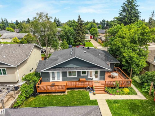 Dark gray exterior siding with white trim, dark shingle roofing, and a spacious wood deck - 8212 148 Street Nw, Edmonton, AB 
