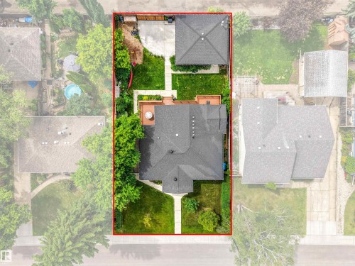 Manicured grounds featuring a spacious main residence, detached auxiliary building, multi-level decking, and paved patio areas - 8212 148 Street Nw, Edmonton, AB 