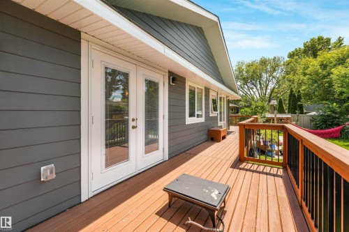 Expansive exterior deck featuring a wood-finish floor and wood railing with black balusters - 8212 148 Street Nw, Edmonton, AB 