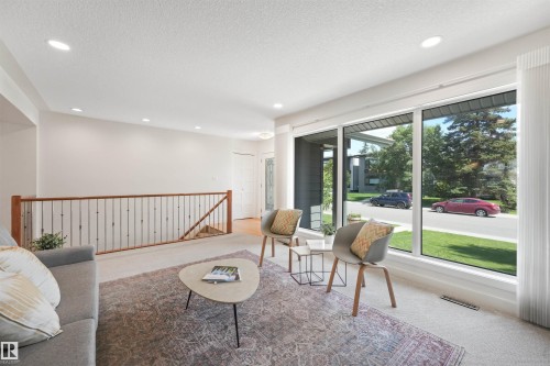 Expansive windows, recessed lighting, and a wood-finish railing with metal balusters - 8212 148 Street Nw, Edmonton, AB 