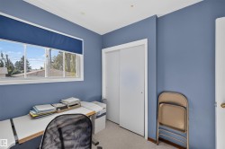 Window with a blue roller shade, white trim, and a partial outdoor landscape - 
