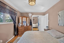 Hardwood-style flooring, a window with natural light, a ceiling-mounted light fixture, and a mirrored closet door - 