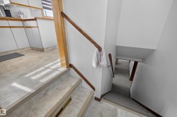 Staircase featuring wood handrails and carpeted treads - 