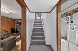 Central hallway with wooden trim detailing and staircase access to upper level - 