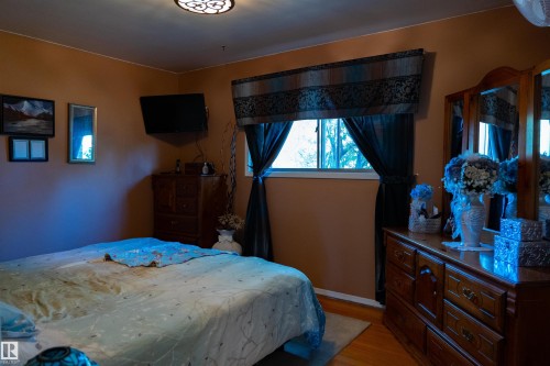 Hardwood flooring, window with natural light, wall-mounted light fixture, and warm-toned wall paint - 11119 137 Avenue Nw, Edmonton, AB 