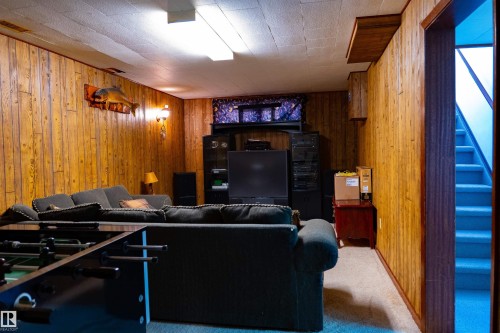 Wood-paneled walls with integrated lighting, recessed ceiling panels, and a carpeted floor - 11119 137 Avenue Nw, Edmonton, AB 
