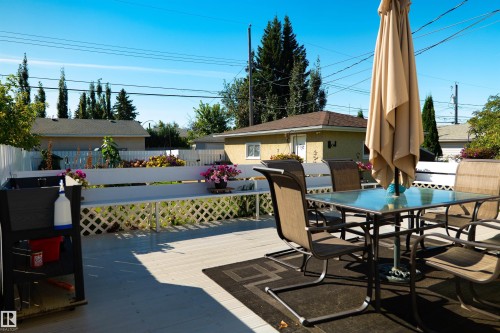 Expansive outdoor deck with a white lattice railing and a built-in bench - 11119 137 Avenue Nw, Edmonton, AB 