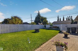 Private backyard featuring a paver patio and a white picket fence - 