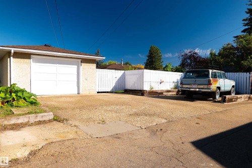 Detached single-car garage with a panel garage door, stucco exterior, and asphalt shingle roof - 11119 137 Avenue Nw, Edmonton, AB 