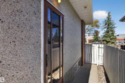 Textured stucco exterior with a brown-framed glass door - 