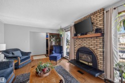 Brick fireplace with a black arched insert and a wood mantel - 