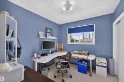 White window frame with a blue roller blind, overhead lighting fixture, and white trim - 
