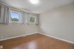 Wood-finish flooring, multiple windows, and a flush mount ceiling light - 