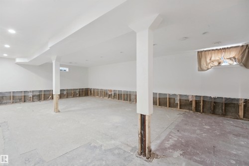 Expansive unfinished space featuring structural columns, exposed wall framing, and recessed ceiling lighting - 13420 117 Avenue Nw, Edmonton, AB 
