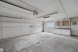 Spacious garage with concrete flooring, built-in cabinetry, and multiple windows for natural light - 