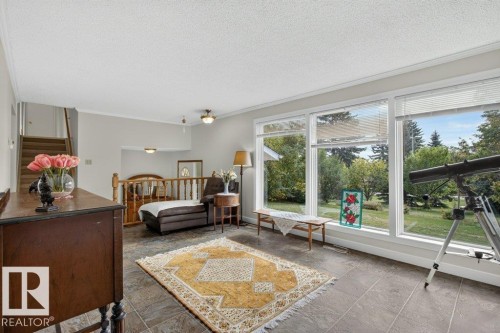 Floor-to-ceiling windows, wood staircase with railing, recessed lighting, ceiling fan, and tiled flooring - #74 22555 Twp Road 530, Rural Strathcona County, AB 
