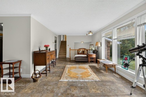 Spacious living area featuring tile flooring, large windows, and crown molding - #74 22555 Twp Road 530, Rural Strathcona County, AB 