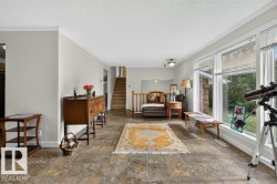 Spacious living area featuring tile flooring, large windows, and crown molding - 