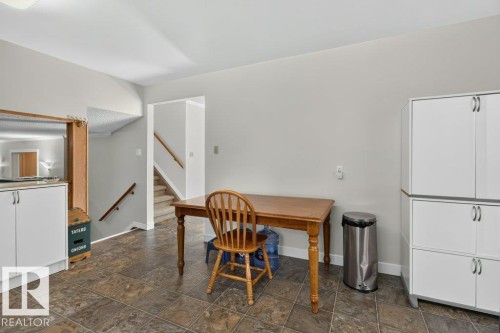 Tiled flooring throughout, white cabinetry with silver hardware, and a staircase with wood-finish handrails - #74 22555 Twp Road 530, Rural Strathcona County, AB 