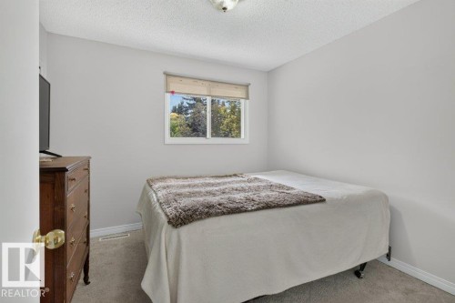 Wall-to-wall carpeting with light gray walls, a window with a roller shade, and a flush mount ceiling light - #74 22555 Twp Road 530, Rural Strathcona County, AB 