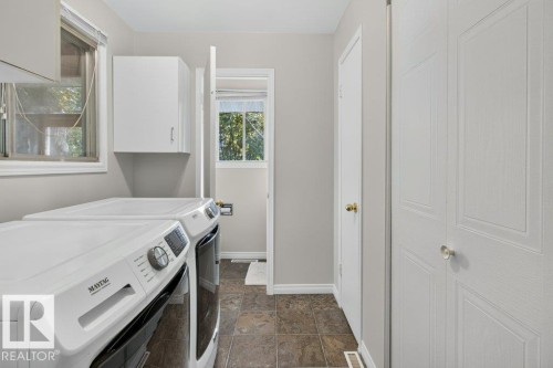 Laundry area with tiled flooring, white built-in cabinetry, and a window - #74 22555 Twp Road 530, Rural Strathcona County, AB 