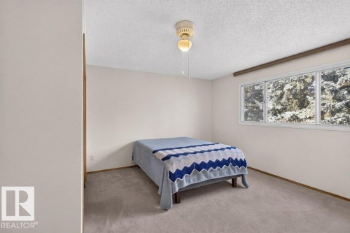 Textured ceiling with a ceiling-mounted light fixture, neutral wall paint, and wall-to-wall carpeting - #74 22555 Twp Road 530, Rural Strathcona County, AB 