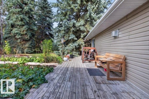 Exterior wood-finish decking with a light-colored vinyl-sided wall and a built-in light fixture - #74 22555 Twp Road 530, Rural Strathcona County, AB 