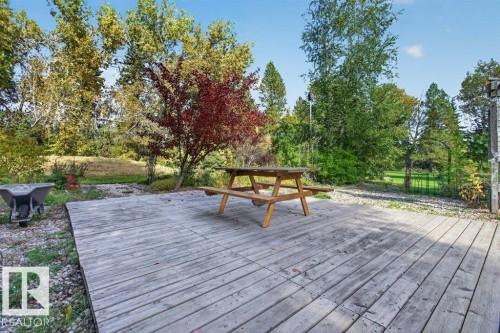 Expansive wood decking with surrounding mature trees and natural landscaping - #74 22555 Twp Road 530, Rural Strathcona County, AB 