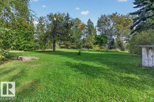 Expansive green lawn with mature trees and natural landscaping - #74 22555 Twp Road 530, Rural Strathcona County, AB 