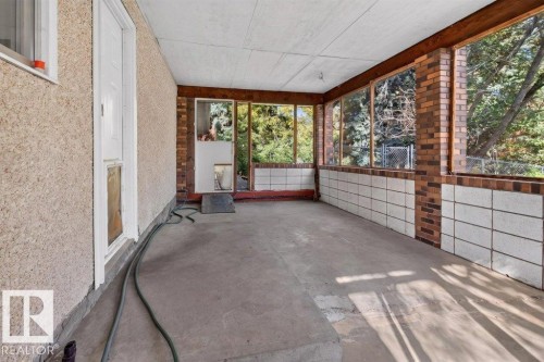 Enclosed patio featuring a concrete floor, exposed brick columns, and a half-wall of white block - #74 22555 Twp Road 530, Rural Strathcona County, AB 