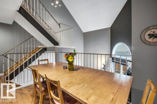 Expansive vaulted ceilings, wood-finish flooring, and a decorative staircase with white balusters - #24 3811 85 St Nw, Edmonton, AB 