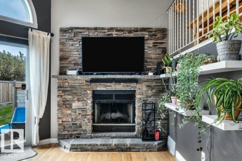 Stacked stone fireplace surround with a stone hearth - #24 3811 85 St Nw, Edmonton, AB 