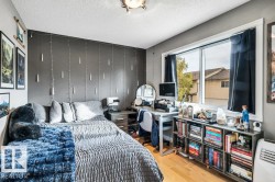 Wood-finish flooring, a large window, a built-in shelving unit, and a ceiling-mounted light fixture - 