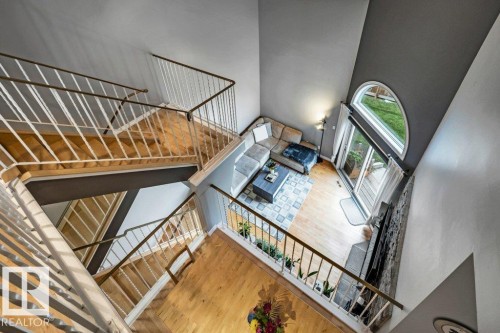Multi-level interior featuring wood flooring and white balusters - #24 3811 85 St Nw, Edmonton, AB 