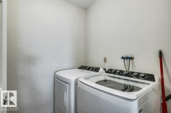 Laundry area featuring white walls and a textured ceiling - 