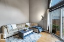 Vaulted ceiling with an arched window, light wood-finish flooring, and sliding glass doors leading to the outdoor area - #24 3811 85 St Nw, Edmonton, AB 