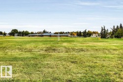 Expansive green space featuring large grassy areas and distant buildings - 