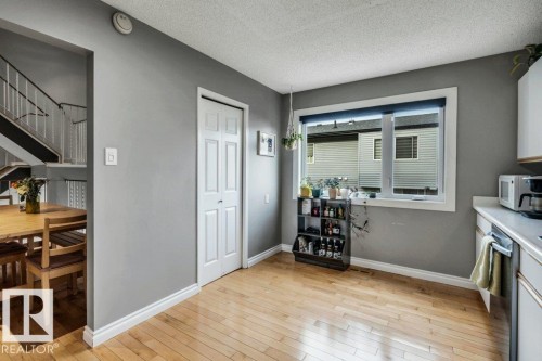 Hardwood flooring, painted interior walls, white window trim, white bi-fold door, and white ceiling - #24 3811 85 St Nw, Edmonton, AB 
