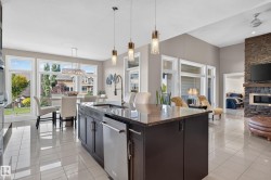 Kitchen island with a granite countertop, integrated sink, and pendant lighting - 