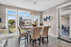 Large windows, a glass-paneled exterior door, and light-toned tile flooring - 