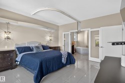 Recessed ceiling lighting, two decorative pendant lights, light-toned wall paint, tile flooring, and glass-paneled doors - 