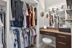 Built-in closet system with multiple hanging rods, recessed lighting, and integrated shelving - 