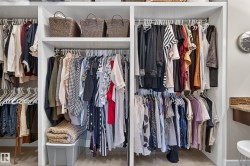 Built-in closet system with multiple shelving units, integrated hanging rods, and wood-finish flooring - 