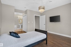 Wood-finish flooring, neutral wall tones, and a crystal drop chandelier - 