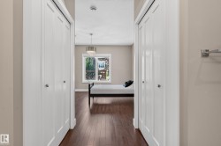 Wood-finish flooring, white bi-fold closet doors with chrome hardware, and a window providing natural light - 