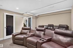 Recessed lighting, carpeted flooring, double glass panel doors, neutral wall tones, and a retractable ceiling screen - 