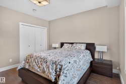 White bi-fold closet doors, wood-finish flooring, neutral wall paint, and ceiling-mounted light fixture - 