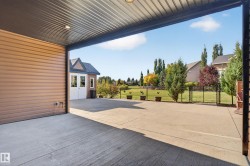 Expansive concrete patio with a covered overhead structure and recessed lighting - 