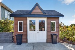 Shed structure with brown siding, white French doors, and two vertical windows - 